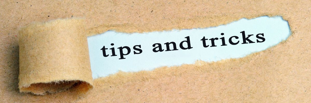 The phrase "tips and tricks" shown through a torn opening in brown paper.